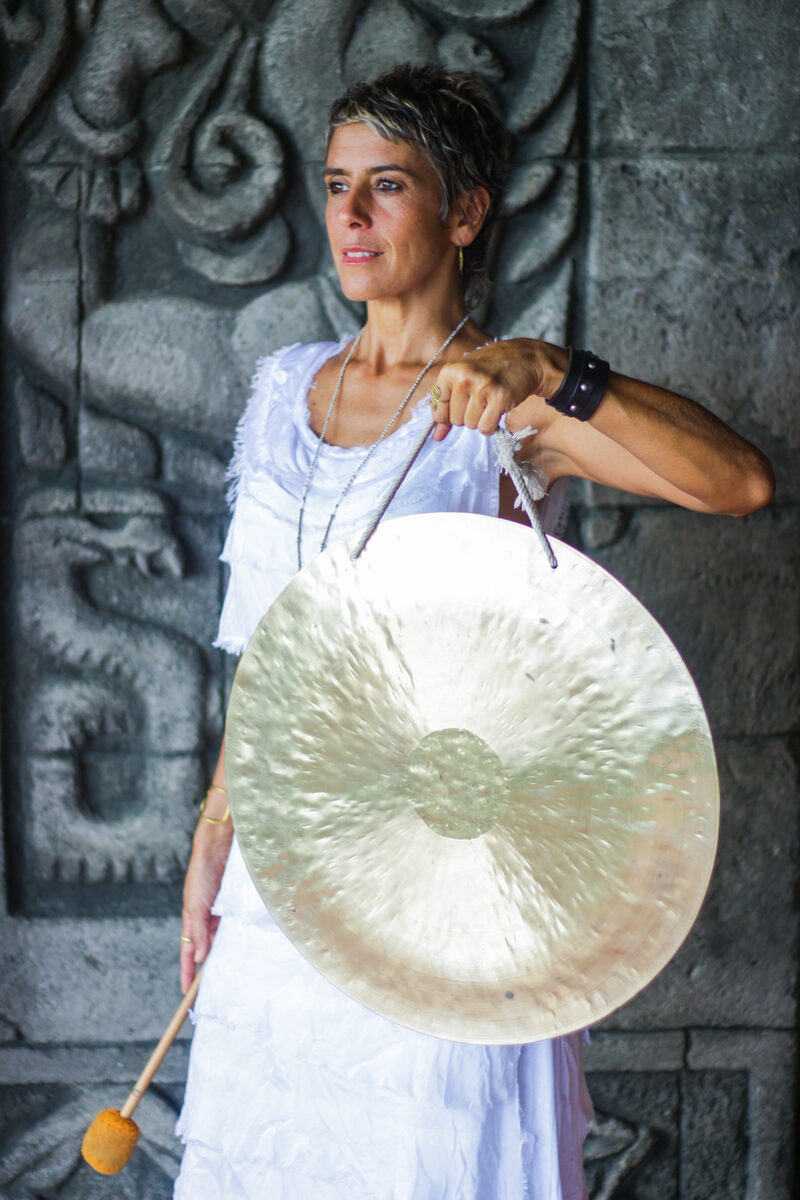 Marianela Ortiz — sosteniendo wind gong, muro tallado